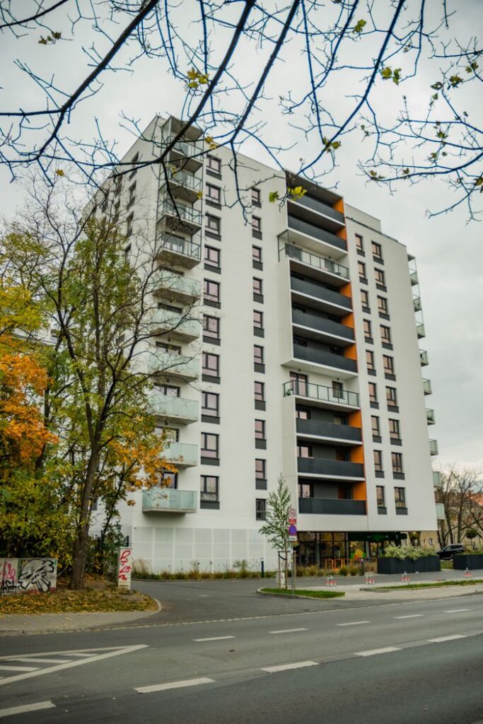 Contemporary apartment building with fall foliage in cityscape.