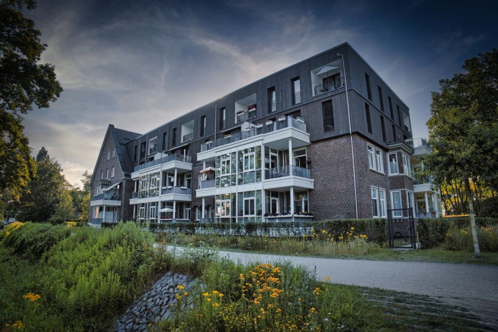 Contemporary residential building surrounded by lush greenery in summer.